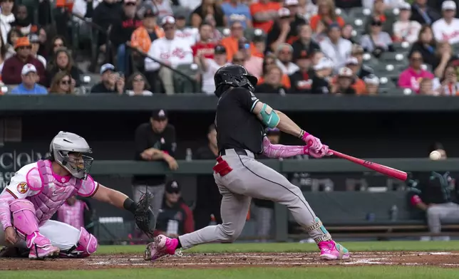 Arizona Diamondbacks' Corbin Carroll, right, hits during a baseball game against the Baltimore Orioles, Sunday, May 12, 2024, in Baltimore. (AP Photo/Jose Luis Magana)