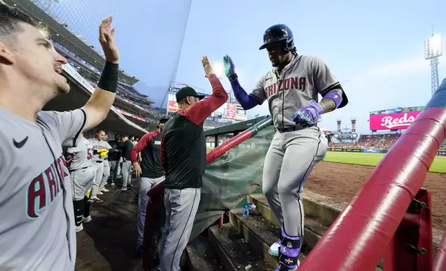 Arizona Diamondbacks' Ketel Marte, right, celebrates with teammates after hitting a solo home run during the seventh inning of a baseball game against the Cincinnati Reds Tuesday, May 7, 2024, in Cincinnati. (AP Photo/Jeff Dean)