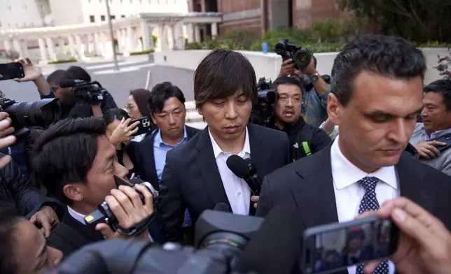 Ippei Mizuhara, center, the former longtime interpreter for the Los Angeles Dodgers baseball star Shohei Ohtani, leaves federal court following his arraignment, Tuesday, May 14, 2024, in Los Angeles. Mizuhara pleaded not guilty Tuesday to bank and tax fraud, a formality ahead of a plea deal he’s negotiated with federal prosecutors in a wide-ranging sports betting case. (AP Photo/Eric Thayer)
