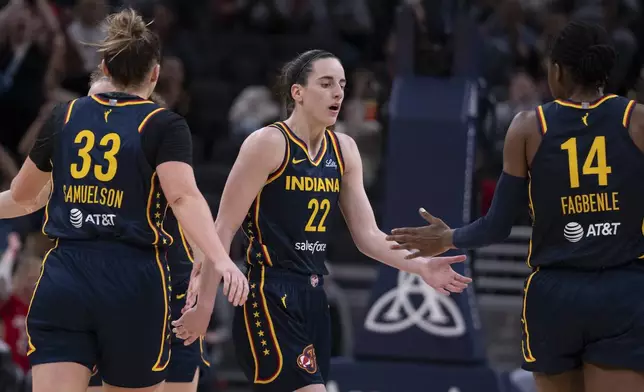 Indiana Fever's Caitlin Clark (22) is congratulated by Temi Fagbenle (14) after Clark hit a 3-point shot against the Atlanta Dream during the second half of a WNBA preseason basketball game Thursday, May 9, 2024, in Indianapolis. (AP Photo/Darron Cummings)