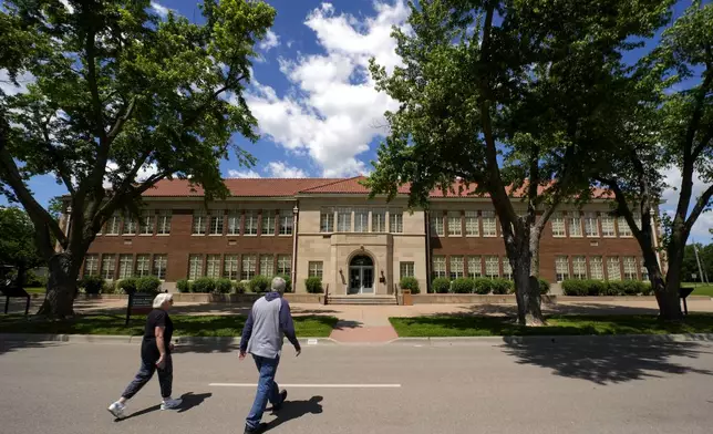 Visitors walk to the former Monroe school, which now houses a national historic site, Friday, May 10, 2024, in Topeka, Kan. The school was at the center of the Brown v. Board of Education Supreme Court ruling ending segregation in public schools 70 years ago. (AP Photo/Charlie Riedel)