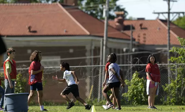 Students at Williams Science and Arts Magnet school play a game Friday, May 10, 2024, in Topeka, Kan. The school is just a block from the former Monroe school, seen in the distance, which was at the center of the Brown v. Board of Education Supreme Court ruling ending segregation in public schools 70 years ago. (AP Photo/Charlie Riedel)