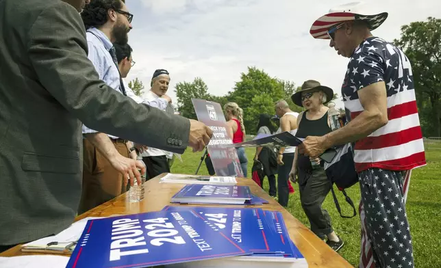 Supporters of the Republican presidential candidate former President Donald Trump pick up posters ahead of a campaign rally in the Bronx borough of New York, Thursday, May. 23, 2024. (AP Photo/Yuki Iwamura)