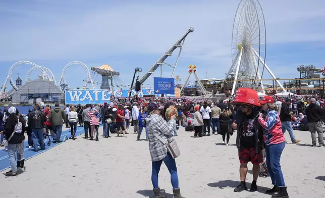 Anthony Pahopin, second right, wears an over-sized Donald Trump cap while posing for a photograph before a campaign rally for Republican presidential candidate former President Trump in Wildwood, N.J., Saturday, May 11, 2024. (AP Photo/Matt Rourke)