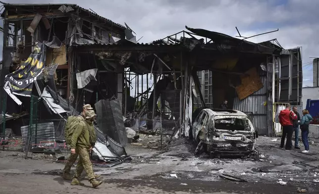 FILE - Ukrainian servicemen pass the scene of a building damaged by Russian attack in Dnipro, Ukraine, April 19, 2024. (AP Photo/Andriy Andriyenko, File)