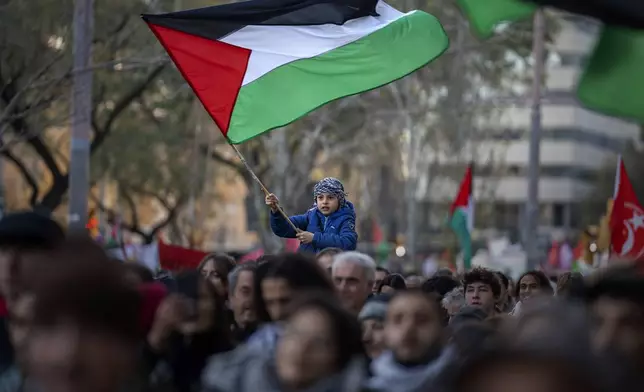 FILE - A boy waves a Palestinian flag as demonstrators march during a protest in support of Palestinians and calling for an immediate ceasefire in Gaza, in Barcelona, Spain, on Jan. 20, 2024. European Union countries Spain and Ireland as well as Norway on Wednesday announced dates for recognizing Palestine as a state. (AP Photo/Emilio Morenatti, File)