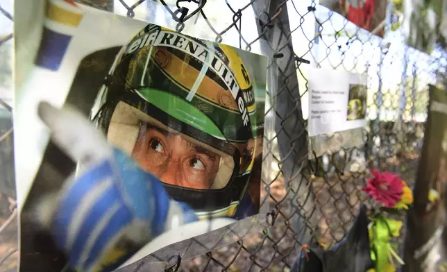 FILE - Pictures of late Brazilian race car driver Ayrton Senna hangs on the the corner where he was died, during the third practice session ahead of Sunday's Emilia Romagna Formula One Grand Prix, at the Enzo and Dino Ferrari racetrack, in Imola, Italy, Saturday, Oct. 31, 2020. The 30th anniversary of Ayrton Senna’s death is commemorated on Wednesday, May 1, 2024, with a memorial on the Imola track where he crashed during the 1994 San Marino Grand Prix. (Jennifer Lorenzini, Pool via AP, File)