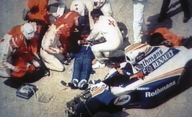 FILE- In this TV image, rescue crew members give first aid to unconscious formula one driver Ayrton Senna, lying mortally injured, beside his wrecked car after the Brazillian driver crashed against the course wall during the Grand Prix of San Marino, in this file photo dated Sunday May 1, 1994, in Imola, Italy. The 30th anniversary of Ayrton Senna’s death is commemorated on Wednesday, May 1, 2024, with a memorial on the Imola track where he crashed during the 1994 San Marino Grand Prix. (AP Photo/File)