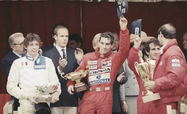 FILE - Prince Albert of Monaco, left, applauds Brazil's Ayrton Senna, center, winner of the Monaco formula One grand prix ahead of Prost, right, on the podium in Monaco Sunday, May 7, 1989. The 30th anniversary of Ayrton Senna’s death is commemorated with a memorial on the Imola track where he crashed during the 1994 San Marino Grand Prix. (AP Photo/Gilbert Tourte, File)