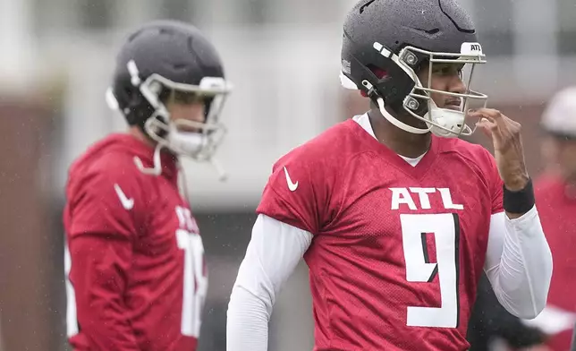 Atlanta Falcons quarterbacks Michael Penix Jr., right, and Kirk Cousins, left, run drills during an NFL football mini training camp practice on Tuesday, May 14, 2024, in Flowery Branch, Ga. (AP Photo/Brynn Anderson)
