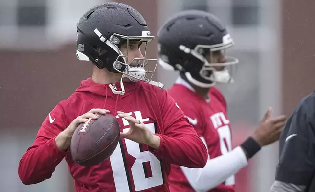 Atlanta Falcons quarterbacks Kirk Cousins, left, and Michael Penix Jr., right, run drills during an NFL football mini training camp practice on Tuesday, May 14, 2024, in Flowery Branch, Ga. (AP Photo/Brynn Anderson)