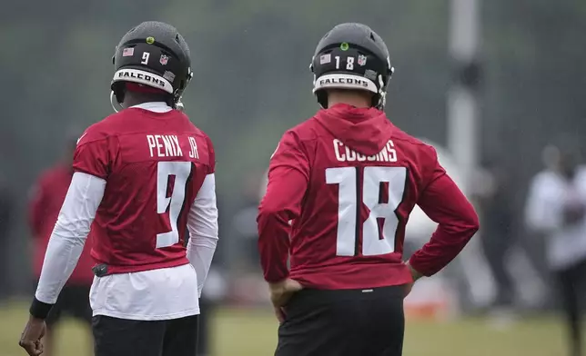 Atlanta Falcons quarterbacks Kirk Cousins, right, and Michael Penix Jr., run drills during an NFL football mini training camp practice on Tuesday, May 14, 2024, in Flowery Branch, Ga. (AP Photo/Brynn Anderson)