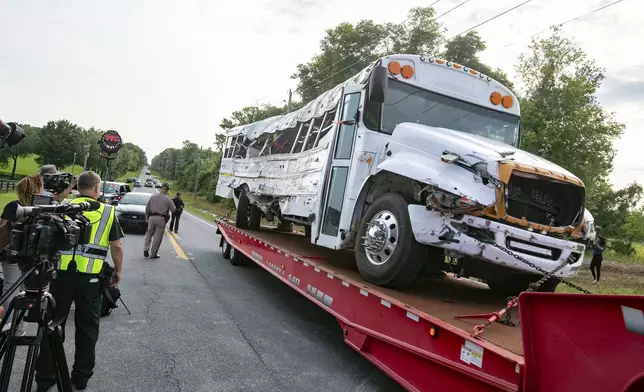A bus is removed after it collied with a small pickup truck killing eight of the more than 50 migrant workers in the bus, Tuesday, May 14, 2024, in Ocala, Fla. The driver of the pick up, Bryan Maclean Howard, was charged with eight counts of DUI manslaughter. (AP Photo/Alan Youngblood)