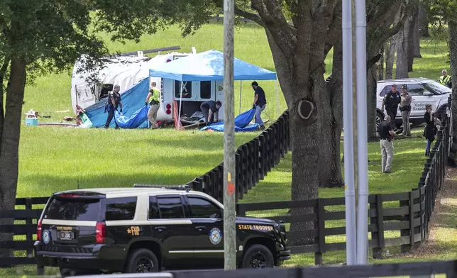 Authorities work at the scene of a deadly crash after a bus carrying farmworkers collided with a pickup truck on State Road 40 Tuesday, May 14, 2024, near Dunnellon, Fla. (AP Photo/Alan Youngblood)