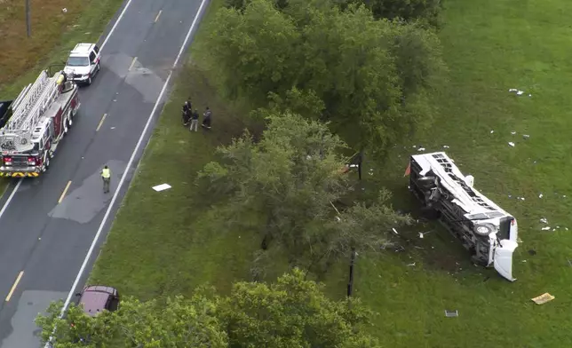 Emergency workers work the scene of a fatal bus crash carrying laborers that overturned Tuesday morning, May 14, 2024, in Ocala, Fla. (Doug Engle/Ocala Star-Banner via AP)