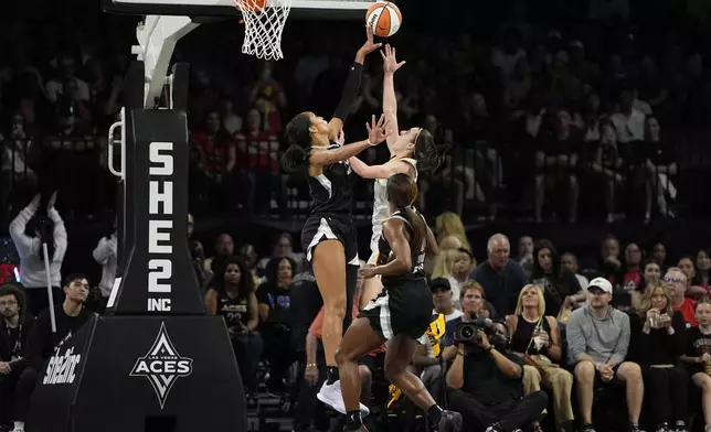 Las Vegas Aces center A'ja Wilson, left, blocks a shot by Indiana Fever guard Caitlin Clark during the first half of a WNBA basketball game Saturday, May 25, 2024, in Las Vegas. (AP Photo/John Locher)