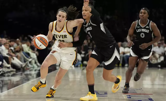 Indiana Fever guard Caitlin Clark (22) drives against Las Vegas Aces forward Alysha Clark (7) during the second half of a WNBA basketball game Saturday, May 25, 2024, in Las Vegas. (AP Photo/John Locher)