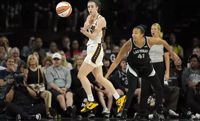 Indiana Fever guard Caitlin Clark (22) passes against Las Vegas Aces center Kiah Stokes (41) during the first half of a WNBA basketball game Saturday, May 25, 2024, in Las Vegas. (AP Photo/John Locher)