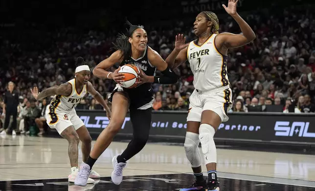 Las Vegas Aces center A'ja Wilson (22) drives against Indiana Fever forward NaLyssa Smith (1) during the first half of a WNBA basketball game Saturday, May 25, 2024, in Las Vegas. (AP Photo/John Locher)