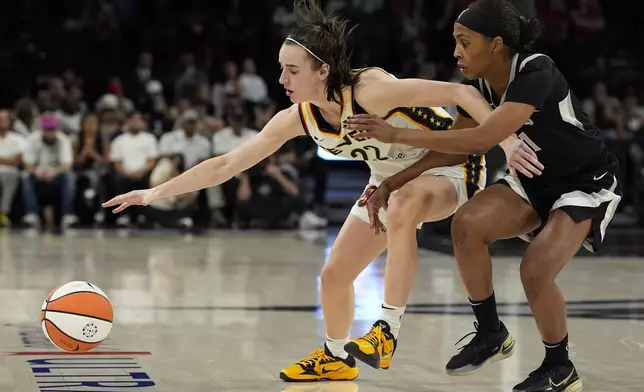 Indiana Fever guard Caitlin Clark (22) and Las Vegas Aces guard Sydney Colson (51) vie for the ball during the second half of a WNBA basketball game Saturday, May 25, 2024, in Las Vegas. (AP Photo/John Locher)