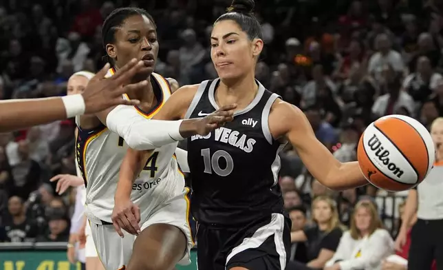 Las Vegas Aces guard Kelsey Plum (10) passes around Indiana Fever center Temi Fagbenle (14) during the first half of a WNBA basketball game Saturday, May 25, 2024, in Las Vegas. (AP Photo/John Locher)