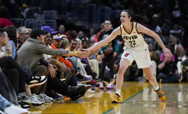 Indiana Fever guard Caitlin Clark (22) greets Ashton Kutcher after making a 3-pointer during the second half of a WNBA basketball game against the Los Angeles Sparks in Los Angeles, Friday, May 24, 2024. (AP Photo/Ashley Landis)