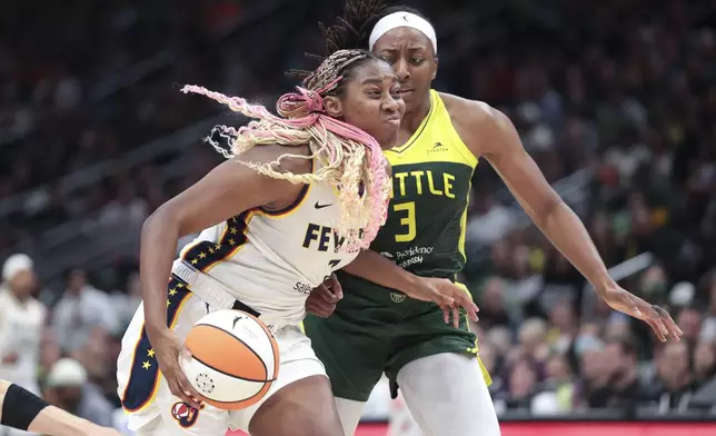Indiana Fever forward Aliyah Boston drives as Seattle Storm forward Nneka Ogwumike defends during the second half of a WNBA basketball game Wednesday, May 22, 2024, in Seattle. The Storm won 85-83. (AP Photo/Jason Redmond)
