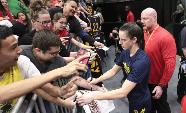 Indiana Fever guard Caitlin Clark signs autographs before the team's WNBA basketball game against the Seattle Storm, Wednesday, May 22, 2024, in Seattle. (AP Photo/Jason Redmond)