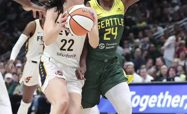 Indiana Fever guard Caitlin Clark (22) is defended by Seattle Storm guard Jewell Loyd (24) during the second half of a WNBA basketball game Wednesday, May 22, 2024, in Seattle. The Storm won 85-83. (AP Photo/Jason Redmond)