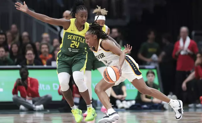 Indiana Fever guard Kelsey Mitchell, right, drives against Seattle Storm guard Jewell Loyd (24) during the first half of a WNBA basketball game Wednesday, May 22, 2024, in Seattle. (AP Photo/Jason Redmond)