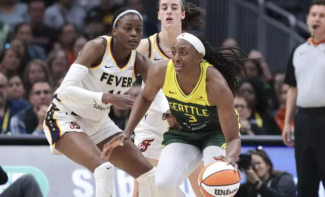 Seattle Storm forward Nneka Ogwumike (3) moves the ball as Indiana Fever center Temi Fagbenle, left, and guard Caitlin Clark defend during the second half of a WNBA basketball game Wednesday, May 22, 2024, in Seattle. The Storm won 85-83. (AP Photo/Jason Redmond)