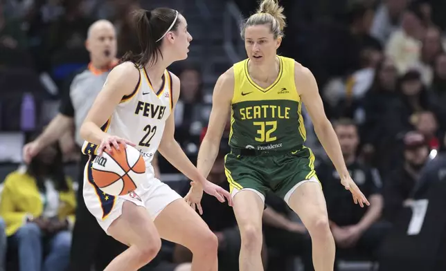 Indiana Fever guard Caitlin Clark (22) dribbles the ball as Seattle Storm guard Sami Whitcomb (32) defends during the first half of a WNBA basketball game Wednesday, May 22, 2024, in Seattle. (AP Photo/Jason Redmond)