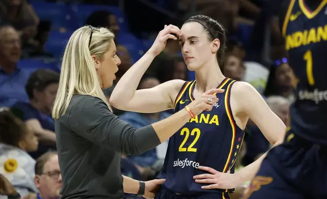 Indiana Fever head coach Christine Sides, left, talks to Indiana Fever guard Caitlyn Clark (22) as they play the Dallas Wings during the first half of an WNBA basketball game in Arlington, Texas, Friday, May 3, 2024. (AP Photo/Michael Ainsworth)