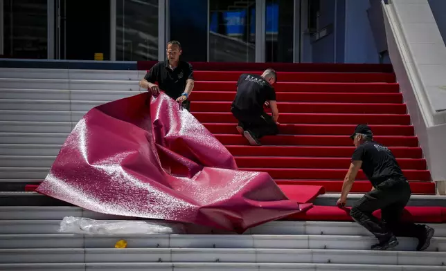 Festival workers prepare the red carpet during preparations for the 77th international film festival, Cannes, southern France, Monday, May 13, 2024. The Cannes film festival runs from May 14 until May 25, 2024. (AP Photo/Andreea Alexandru)