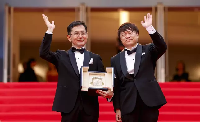 Goro Miyazaki, left, and Kenichi Yoda pose for photographers with the Studio Ghibli honorary Palme d'Or upon arrival at the premiere of the film 'The Apprentice' at the 77th international film festival, Cannes, southern France, Monday, May 20, 2024. (Photo by Vianney Le Caer/Invision/AP)