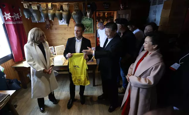 Chinese President Xi Jinping, second right, and his wife Peng Liyuan, right, French President Emmanuel Macron, holding a Tour de Francecycling race jersey and his wife Brigitte Macron, left, discuss in a restaurant, Tuesday, May 7, 2024 at the Tourmalet pass, in the Pyrenees mountains. French president is hosting China's leader at a remote mountain pass in the Pyrenees for private meetings, after a high-stakes state visit in Paris dominated by trade disputes and Russia's war in Ukraine. French President Emmanuel Macron made a point of inviting Chinese President Xi Jinping to the Tourmalet Pass near the Spanish border, where Macron spent time as a child visiting his grandmother. (AP Photo/Aurelien Morissard, Pool)