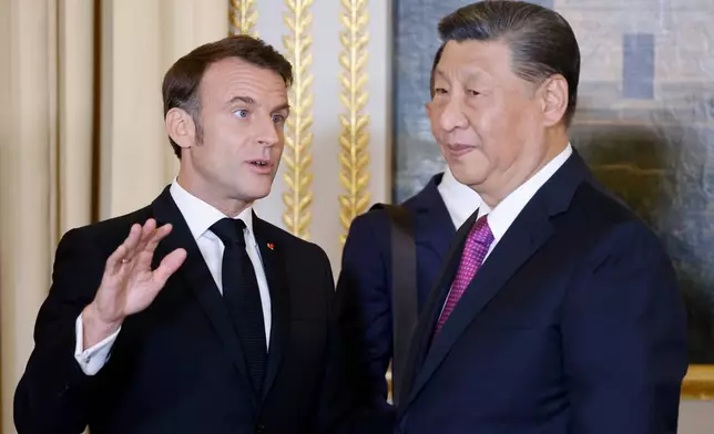 French President Emmanuel Macron talks with Chinese President Xi Jinping during a a state dinner at the Elysee Palace in Paris, Monday, May 6, 2024. French President Emmanuel Macron put trade disputes and Ukraine-related diplomatic efforts on top of the agenda for talks with Chinese President Xi Jinping, who arrived in France for a two-day state visit opening his European tour. (Ludovic Marin, Pool via AP)