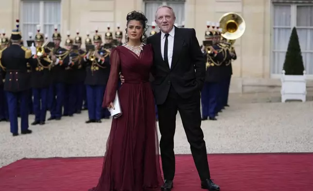 Salma Hayek and François-Henri Pinault, center, CEO of luxury group Kering, arrive to attend a state diner hosted by French President Emmanuel Macron for China's President Xi Jinping at the Elysee Palace, Monday, May 6, 2024 in Paris. (AP Photo/Thibault Camus)