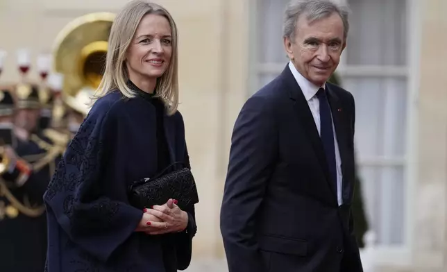 LVMH luxury group CEO Bernard Arnault and his daughter Delphine arrive for a state diner hosted by French President Emmanuel Macron for China's President Xi Jinping at the Elysee Palace, Monday, May 6, 2024 in Paris. (AP Photo/Thibault Camus)