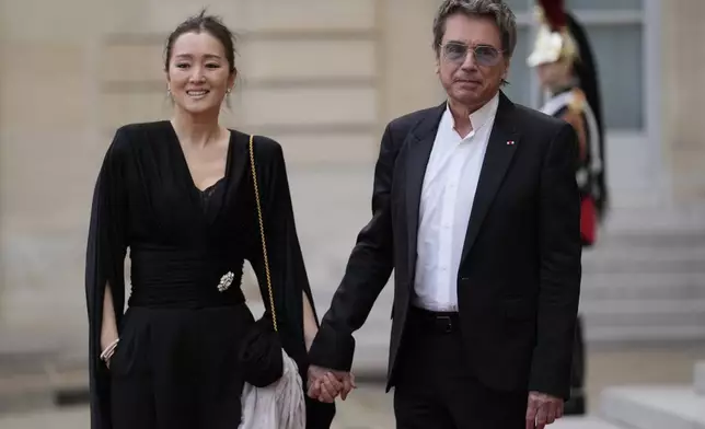 French musician Jean-Michel Jarre and Chinese actress Gong Li arrive for a state diner hosted by French President Emmanuel Macron for China's President Xi Jinping at the Elysee Palace, Monday, May 6, 2024 in Paris. (AP Photo/Thibault Camus)