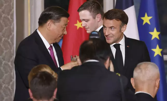French President Emmanuel Macron, right, toasts with Chinese President Xi Jinping during a a state dinner at the Elysee Palace in Paris, Monday, May 6, 2024. French President Emmanuel Macron put trade disputes and Ukraine-related diplomatic efforts on top of the agenda for talks with Chinese President Xi Jinping, who arrived in France for a two-day state visit opening his European tour. (Ludovic Marin, Pool via AP)