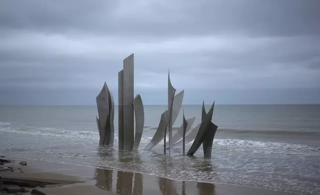 The monument called Les Braves, dedicated to the American soldiers who landed on Omaha Beach on D-Day, is seen on Omaha Beach at sunset, in Saint-Laurent-sur-Mer, Normandy, Thursday, April 11, 2024. On D-Day, Charles Shay was a 19-year-old Native American army medic who was ready to give his life — and actually saved many. Now 99, he's spreading a message of peace with tireless dedication as he's about to take part in the 80th celebrations of the landings in Normandy that led to the liberation of France and Europe from Nazi Germany occupation. (AP Photo/Thibault Camus)