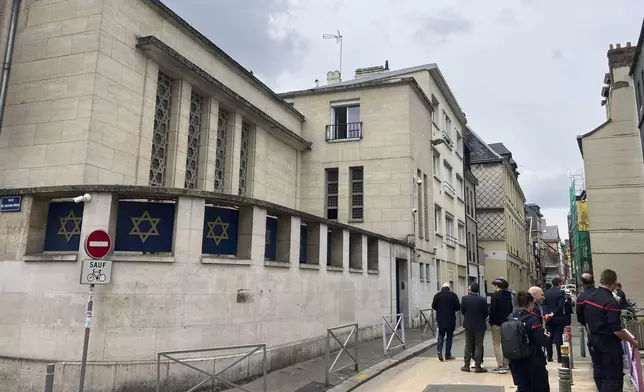 Firemen stand in front the synagogue in Rouen after a man armed with a knife and a metal bar is suspected of having set fire, Friday, May 17, 2024. French police have shot and killed a man armed with a knife and a metal bar who is suspected of having set fire to a synagogue in the Normandy city of Rouen. French police said officers were alerted early Friday morning that smoke was rising from the synagogue and came face to face with the man when they got there. (AP Photo/Jeffrey Schaeffer)