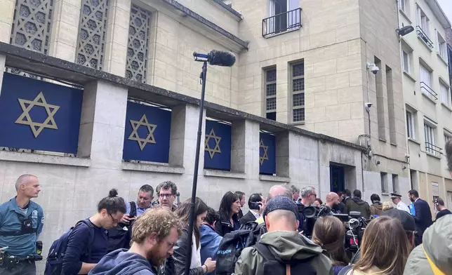 Journalists gather in front of the synagogue in Rouen, Friday, May 17, 2024. French police have shot and killed a man armed with a knife and a metal bar who is suspected of having set fire to a synagogue in the Normandy city of Rouen. French police said officers were alerted early Friday morning that smoke was rising from the synagogue and came face to face with the man when they got there. (AP Photo/Oleg Cetinic)
