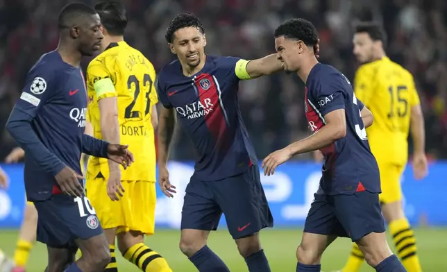 PSG's Marquinhos, centre, and PSG's Warren Zaire-Emery, right, react during the Champions League semifinal second leg soccer match between Paris Saint-Germain and Borussia Dortmund at the Parc des Princes stadium in Paris, France, Tuesday, May 7, 2024. (AP Photo/Lewis Joly)