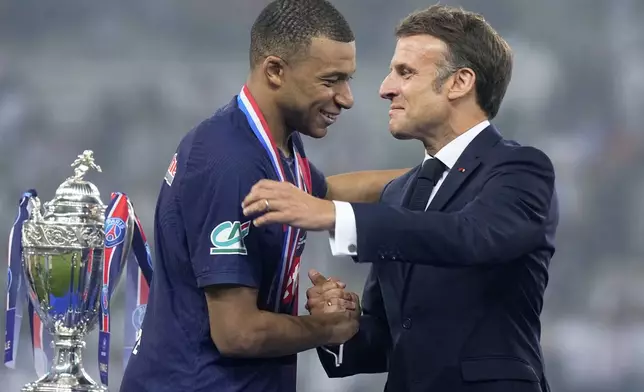 French President Emmanuel Macron greets PSG's Kylian Mbappe during the presentation ceremony after the French Cup final soccer match between Lyon and PSG at the Pierre Mauroy stadium in Villeneuve d'Ascq, northern France, Saturday, May 25, 2024. PSG won the match 2-1. (AP Photo/Michel Euler)