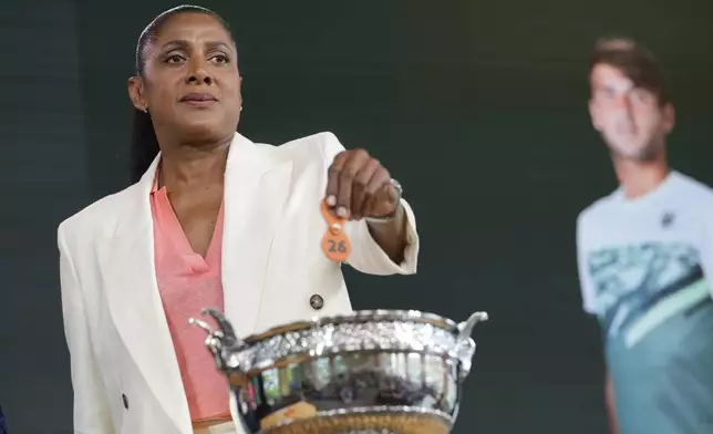 Former French athletic champion Marie-Jose Perec picks up a token during the draw for the French Tennis Open at the Roland Garros stadium, Thursday, May 23, 2024 in Paris. The tournament starts Sunday May 26, 2024. (AP Photo/Thibault Camus)