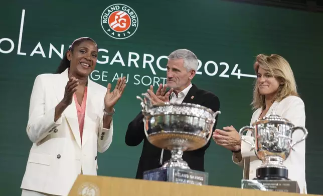 Former French athletic champion Marie-Jose Perec, left, Gilles Moretton, head of the French Tennis Federation (FFT), center, and tournament director Amelie Mauresmo applaud during the draw for the French Tennis Open at the Roland Garros stadium, Thursday, May 23, 2024 in Paris. The tournament starts Sunday May 26, 2024. (AP Photo/Thibault Camus)