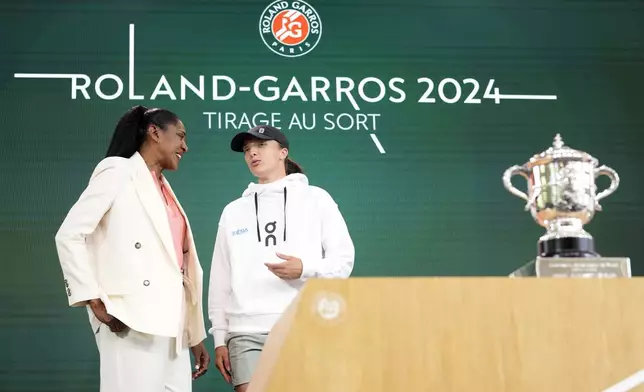 Former French athletic champion Marie-Jose Perec, left, talks with titleholder Poland's Iga Swiatek during the draw for the French Tennis Open at the Roland Garros stadium, Thursday, May 23, 2024 in Paris. The tournament starts Sunday May 26, 2024. (AP Photo/Thibault Camus)