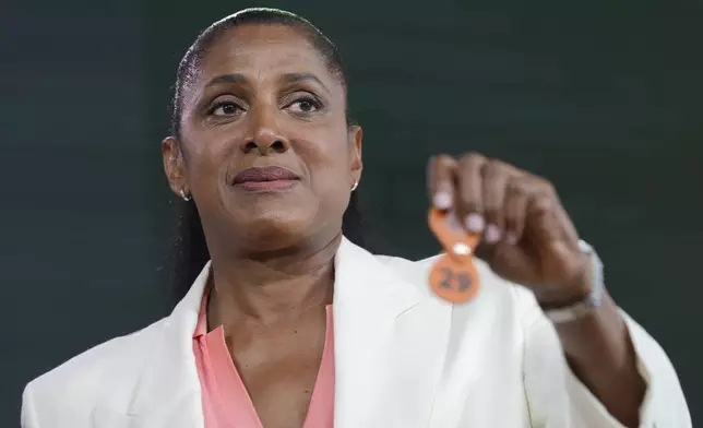 Former French athletic champion Marie-Jose Perec picks up a token during the draw for the French Tennis Open at the Roland Garros stadium, Thursday, May 23, 2024 in Paris. The tournament starts Sunday May 26, 2024. (AP Photo/Thibault Camus)